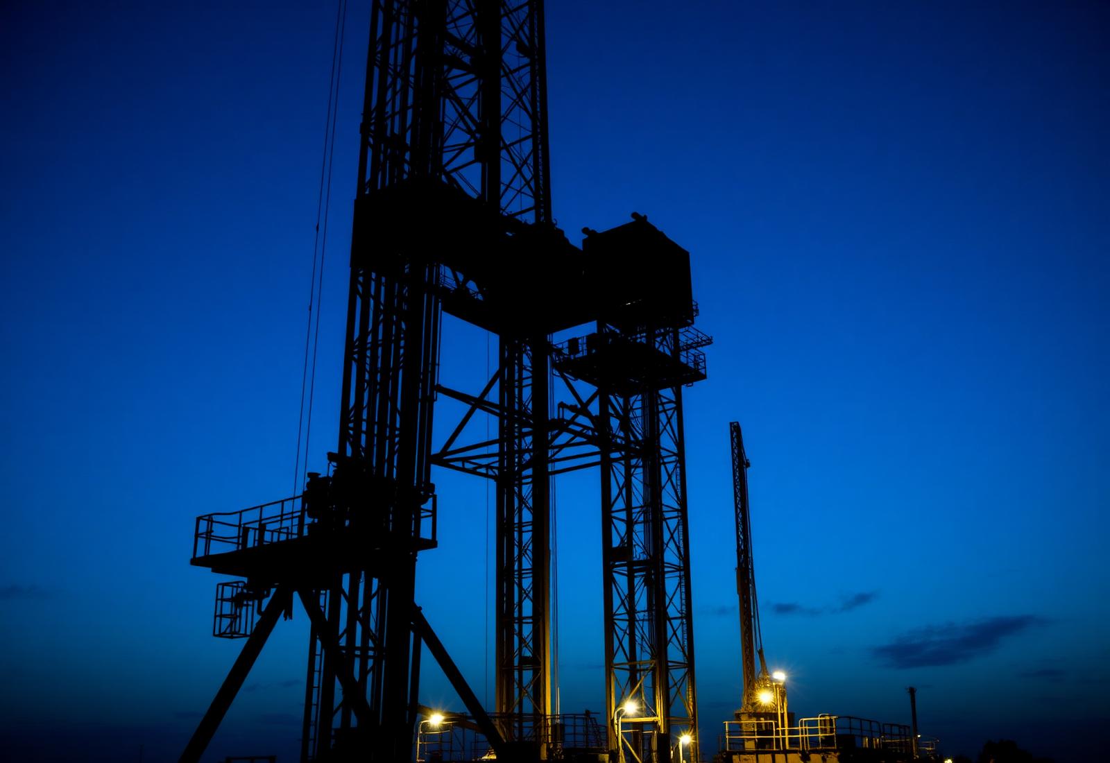 Onshore drilling rig derrick at dusk